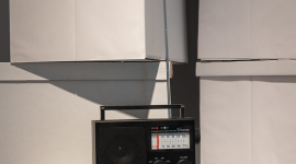 A black radio sits on top of white archival boxes.