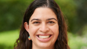 Woman in gray sweater in front of green background