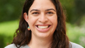 Woman in gray sweater in front of green background