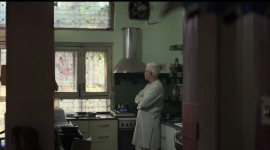 Old man in kitchen looking away from the camera