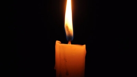 a candle burning against a black background