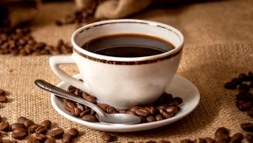 a hot cup of coffee in a porcelain coffee cup with spoon