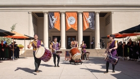 Taiko drummers make music in front of the Thorne Hall entrance on the Occidental College campus