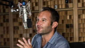 Journalist David Greene in a blue shirt talking into a radio mic