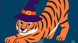 a tiger stretching out with a witch's Halloween hat