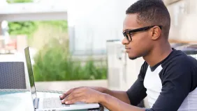 college student working on a laptop intently