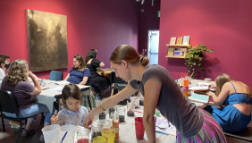 Teacher helping a student select natural ink. 