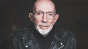medium color portrait of Kip Thorne wearing a black leather motorcycle jacket and glasses, looking directly to camera