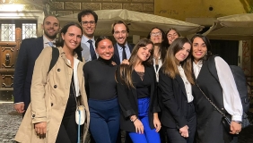 A group of Italian colleagues posing on a Roman street at night