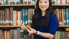 Whitney Tsai Nakashima in front of bookshelf holding birds