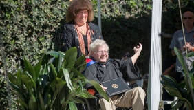 Roger Boesche in a wheelchair being pushed by his wife Mandy