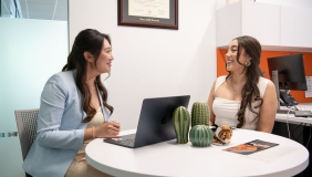 Two women sitting at a table talking as one receives pre-health advising