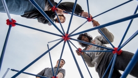 three students shot from below, constructing the Oxyhedron structure