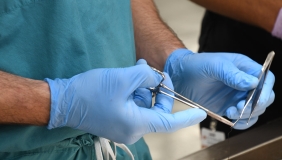a medical student handling scissors and suture material