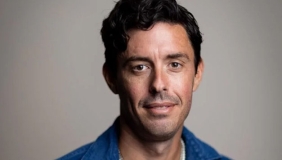 podcaster Tim Miller in a blue shirt with short dark hair looking at the camera