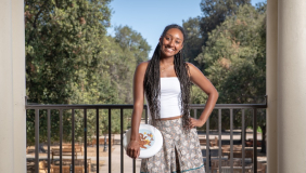 Occidental Student posing for photo on the Los Angeles Campus holding a Frisbee overlooking the Quad