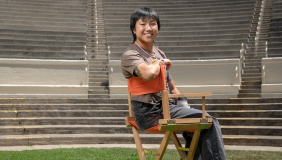 an occidental student sits a directors chair in the Remsen Bird Amphitheater