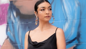 Fox Maxy standing in front of a painted wall 