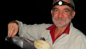 Dr. Rodrigo A. Medellín holding a bat