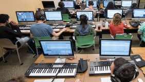 Music production students use electronic keyboards and computers in classroom