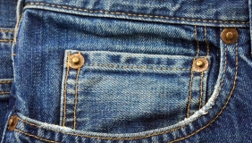 Blue denim pocket with yellow stitching.