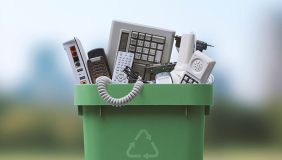 a green recycling bin full of e-waste