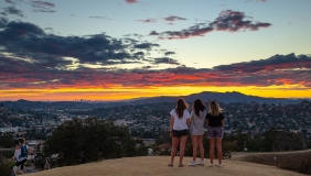 Students standing on Fiji Hill at sunset