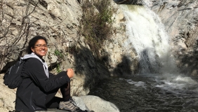 Roshni Katrak-Adefowora sitting in front of a waterfall