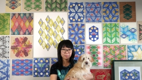 Jennifer Zee holding dog in front of art