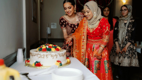 Image of two people cutting cake at a Mock Shaadi (Wedding)