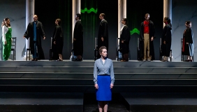 woman standing on stage with a simulated court of supreme court judges behind her