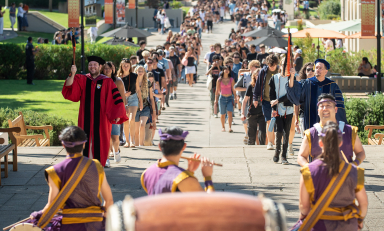 Two long lines of students walking up to Thorne Hall on campus for Convocation