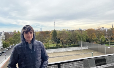 Aidan Garagic '22 in black hooded jacket with grey sky and trees in background