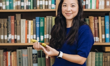 Whitney Tsai Nakashima in front of bookshelf holding birds