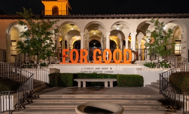 A shot of the Johnson Student Center south entrance with a fountain and the 3-D letters For Good assembled
