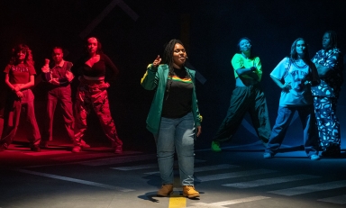 students in hip-hop clothing stand in a formation on the Keck Theater stage