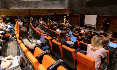 Choi Auditorium filled with people and a guest speaker up front