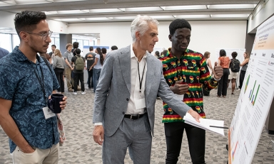 Assistant Professor of Chemistry Raul Navarro and President Stritikus discuss cognitive science major Stephen Sekyere '28's research at Occidental's Summer Research Program Conference on July 30. 