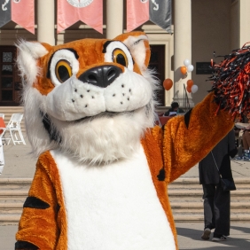Oswald Waving as students and parents walk behind