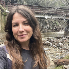 Woman in front of bridge