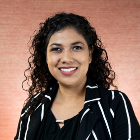 Cecilia Garibay is smiling and wearing a black and white striped shirt