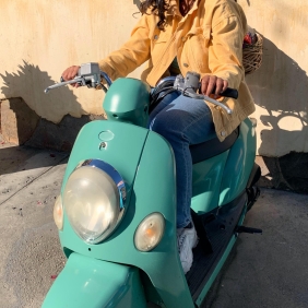 Naya Ramtahal sitting on a motorized scooter