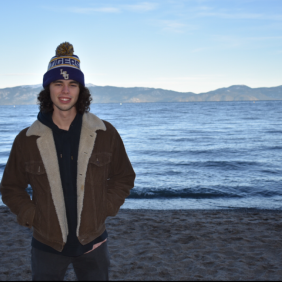 River Flot standing next to a lake with mountains in the background