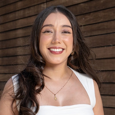 A young Oxy alumna with long brown hair and a big smile