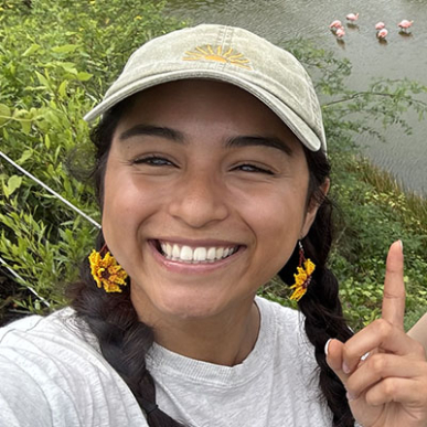 Oxy student Mayah Aguilera '28 smiling with a tan baseball cap on