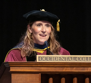 Academic Dean Angie Box in Convocation regalia speaking at the podium