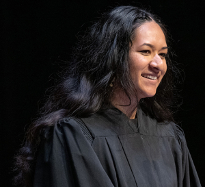 Trisha Bhima, ASOC president, in a black gown speaking at Convocation