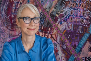 Headshot of artist Alexandra Grant with glasses and a blue shirt