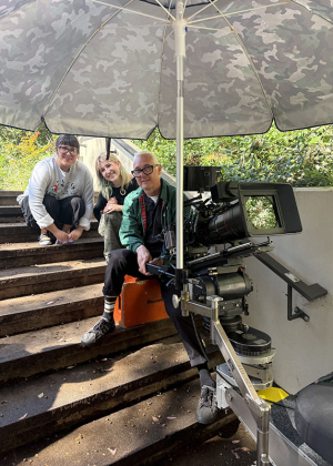 Two Occidental students sitting with a director on set at a television commercial shoot on campus
