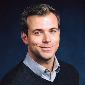 Ian Mariani headshot in navy v-neck sweater
